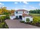 Elegant two-story home featuring a lush landscaped front yard, brick paved driveway, and two-car garage at 4712 Margutta Ct, Sarasota, FL 34240