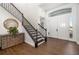 Welcoming foyer features a staircase with wooden treads and iron spindles, tile floors, and a decorative mirror at 4712 Margutta Ct, Sarasota, FL 34240