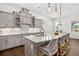 Bright kitchen boasts sleek gray cabinets, pendant lighting, stainless appliances, and a marble countertop island at 4712 Margutta Ct, Sarasota, FL 34240