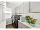Convenient laundry room with gray cabinets, modern washer and dryer, and ample counter space at 4712 Margutta Ct, Sarasota, FL 34240