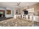 Stylish outdoor kitchen with stone walls, built-in grill, stainless appliances, and a ceiling fan at 4712 Margutta Ct, Sarasota, FL 34240