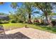 Lush backyard features a well-maintained lawn, mature trees, and a paved patio perfect for outdoor activities and relaxation at 4926 Sabal Lake Cir, Sarasota, FL 34238