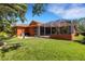 Spacious backyard with mature trees, a lush lawn, and a screened patio offers a private and serene outdoor retreat at 4926 Sabal Lake Cir, Sarasota, FL 34238
