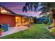 Exterior view of home showcasing the screened patio, lawn, and tropical landscaping at 4926 Sabal Lake Cir, Sarasota, FL 34238