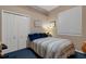 Small bedroom with blue carpet and light walls featuring a striped bed and built-in closet at 4926 Sabal Lake Cir, Sarasota, FL 34238