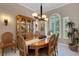 A bright dining room features an oval table, stylish light fixture, and large windows with white shutters at 4926 Sabal Lake Cir, Sarasota, FL 34238