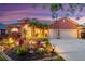 Charming home featuring well-manicured landscaping, a tile roof, and a two-car garage at dusk at 4926 Sabal Lake Cir, Sarasota, FL 34238