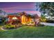 Charming home featuring lush landscaping, including manicured grass, palms, and colorful plants at 4926 Sabal Lake Cir, Sarasota, FL 34238