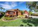 Charming, one-story home features terracotta exterior with a well-manicured lawn and colorful landscaping at 4926 Sabal Lake Cir, Sarasota, FL 34238