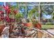A lanai showcasing a rock garden, a tranquil waterfall, and lush plants, inviting relaxation at 4926 Sabal Lake Cir, Sarasota, FL 34238