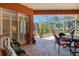 Screened lanai with brick flooring and a comfortable seating area, overlooking the serene backyard at 4926 Sabal Lake Cir, Sarasota, FL 34238