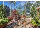 A lanai featuring a rock garden, a peaceful waterfall, and lush greenery, creating a tranquil outdoor oasis at 4926 Sabal Lake Cir, Sarasota, FL 34238