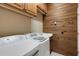 The laundry room features modern washer and dryer appliances, a wash basin, and wooden wall paneling at 4926 Sabal Lake Cir, Sarasota, FL 34238