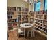 Cozy library with floor-to-ceiling bookshelves, wood floors, and a round table at 4926 Sabal Lake Cir, Sarasota, FL 34238