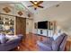 Inviting living room with vaulted ceilings, hardwood floors, large TV, and sliding barn door at 4926 Sabal Lake Cir, Sarasota, FL 34238