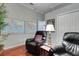 Comfortable living room featuring two leather chairs, a floor lamp and decorative wall hangings at 4926 Sabal Lake Cir, Sarasota, FL 34238