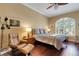 Beautiful bedroom featuring hardwood floors, a ceiling fan, and a large arched window at 4926 Sabal Lake Cir, Sarasota, FL 34238