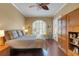Inviting bedroom featuring a hardwood floor, ceiling fan, window shutters, and closet space at 4926 Sabal Lake Cir, Sarasota, FL 34238