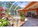 Inviting screened patio featuring a decorative pond, lush landscaping, and comfortable seating area for outdoor relaxation at 4926 Sabal Lake Cir, Sarasota, FL 34238