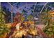 Artistic rock garden with a calming waterfall feature surrounded by vibrant greenery and plants at 4926 Sabal Lake Cir, Sarasota, FL 34238