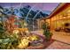 Lush, lighted water feature with tropical plants and a screened lanai, offering a private garden retreat at 4926 Sabal Lake Cir, Sarasota, FL 34238