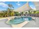 Inviting backyard oasis features a sparkling pool, spa, and shaded seating area at 516 45Th Street W Ct, Palmetto, FL 34221