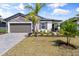 Charming single-story home with stone accents, a paver driveway, and meticulously landscaped front yard with manicured lawn at 5317 Patano Loop, Palmetto, FL 34221
