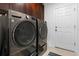 Modern laundry room featuring a washer and dryer, complemented by convenient access to an exterior door at 5317 Patano Loop, Palmetto, FL 34221