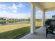 Covered outdoor patio with brick flooring, offering serene views of a tranquil lake and surrounding homes at 5317 Patano Loop, Palmetto, FL 34221