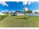 Exterior view of the home featuring a freshly sodded lawn, young trees, and a new fence at 5322 Syracuse Rd, Venice, FL 34293