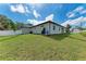 Exterior view of the home featuring a freshly sodded lawn, young trees, and a new fence at 5322 Syracuse Rd, Venice, FL 34293