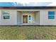 Exterior view of the home featuring a covered porch, sliding glass doors, and a sodded lawn at 5322 Syracuse Rd, Venice, FL 34293