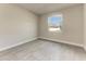 Bright bedroom featuring modern gray floors, white trim, and a window providing ample natural light at 5322 Syracuse Rd, Venice, FL 34293