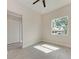 The bedroom features a ceiling fan, a window overlooking the outdoors, and white closet doors at 5322 Syracuse Rd, Venice, FL 34293