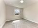 Bright bedroom featuring modern gray floors, white trim, and a window providing ample natural light at 5322 Syracuse Rd, Venice, FL 34293