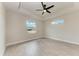 A bedroom featuring gray wood flooring, bright white walls, and two windows at 5322 Syracuse Rd, Venice, FL 34293