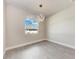 An empty bedroom with light gray wood flooring and a pendant light fixture at 5322 Syracuse Rd, Venice, FL 34293