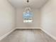 Empty room with neutral walls, grey tile floor, modern light fixture, and a window at 5322 Syracuse Rd, Venice, FL 34293