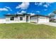 This home features a spacious three-car garage, fresh landscaping, and a sprawling green lawn at 5322 Syracuse Rd, Venice, FL 34293
