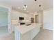 Modern kitchen with white cabinets, stainless steel appliances, a kitchen island, and stylish pendant lighting at 5322 Syracuse Rd, Venice, FL 34293
