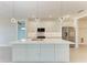 Modern kitchen island with white cabinets, stainless steel appliances, and stylish pendant lighting at 5322 Syracuse Rd, Venice, FL 34293