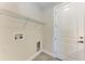Bright laundry room featuring a wire shelf, utility sink hookups, and a modern white door at 5322 Syracuse Rd, Venice, FL 34293