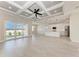 Bright open concept living room with sliding glass doors to the backyard and stylish white kitchen in the background at 5322 Syracuse Rd, Venice, FL 34293