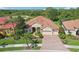 Aerial view of the home showcasing its terracotta roof, manicured landscaping, and three-car garage at 5412 Royal Poinciana Way, North Port, FL 34291