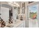 Well-lit bathroom with a large mirror, white countertops, and access to the outdoor patio at 5412 Royal Poinciana Way, North Port, FL 34291