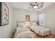 Bright bedroom with two twin beds, ceiling fan, and hardwood flooring at 5412 Royal Poinciana Way, North Port, FL 34291