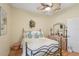 Bedroom featuring a wrought iron bed frame, ceiling fan, light walls, and wood flooring at 5412 Royal Poinciana Way, North Port, FL 34291