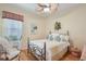 Bright bedroom with a wrought iron bed frame, ceiling fan, and wood flooring at 5412 Royal Poinciana Way, North Port, FL 34291