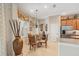 Eat-in kitchen and dining room showcasing a glass-top dining table with seating for four and a large bronze vase at 5412 Royal Poinciana Way, North Port, FL 34291