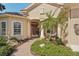 Inviting front porch with brick pathway, lush plants, and comfortable seating area at 5412 Royal Poinciana Way, North Port, FL 34291